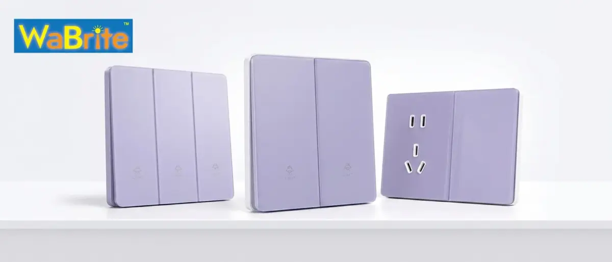 A front three-quarter view product photograph of a coordinated set of three WaBrite smart electrical devices with a modern lavender-purple glass finish and white frames, displayed on a clean white surface. From left to right: a three-gang smart light switch panel with 'LIGHT' text and lamp icons; a two-gang smart light switch panel with 'LIGHT' text and lamp icons; and an Australian standard (Type I) 3-pin power socket with two integrated USB ports (one USB-A, one USB-C) and an adjacent blank single-gang plate. All panels show clean vertical lines and minimalist branding.